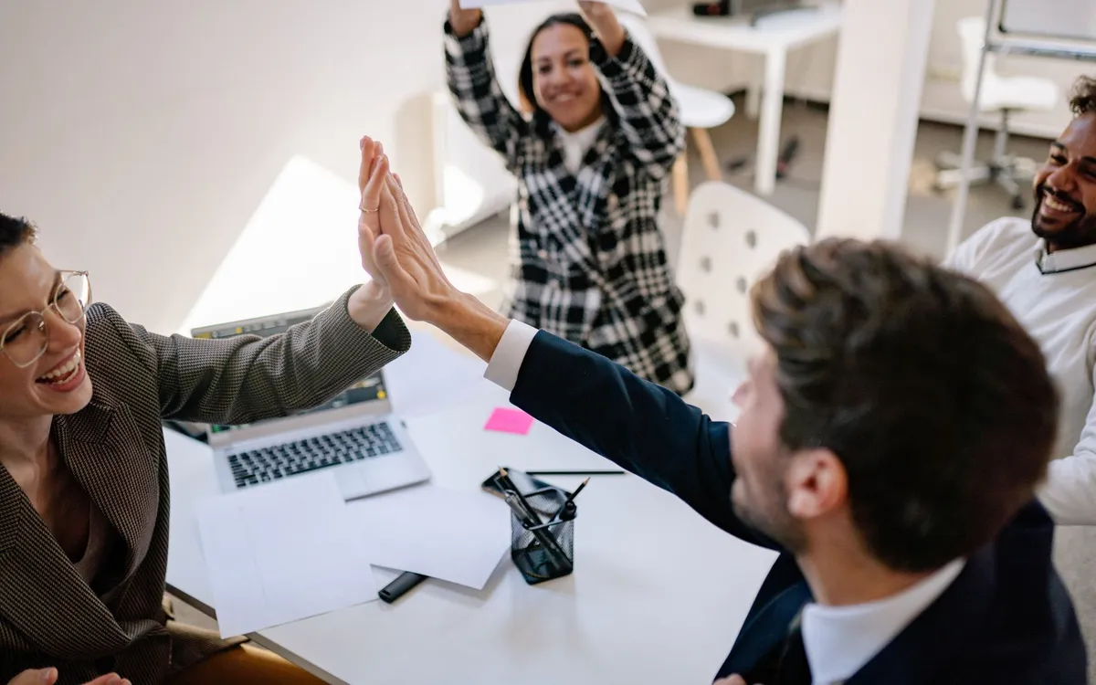 Equipe comemorando um resultado com um high-five