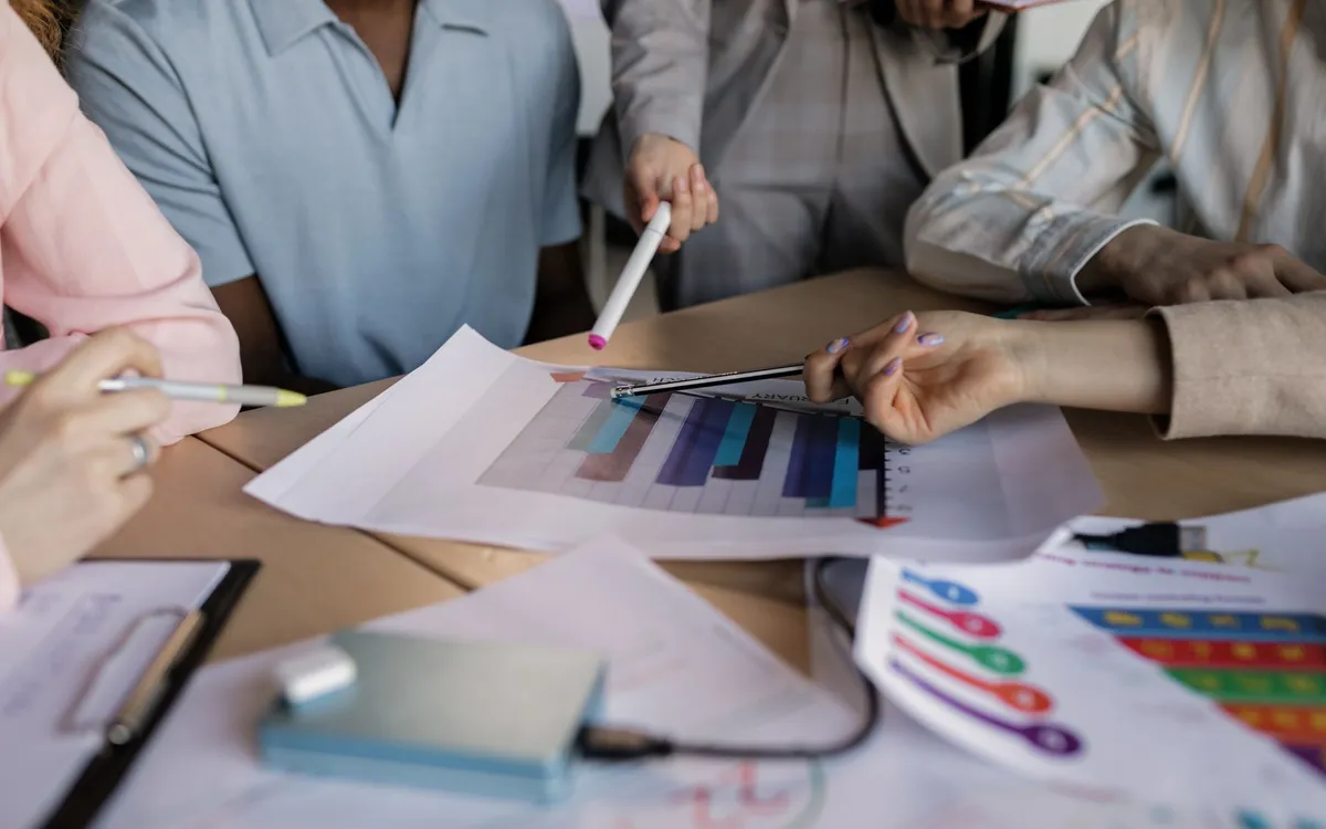 Equipe analisando gráficos e papéis sobre a mesa