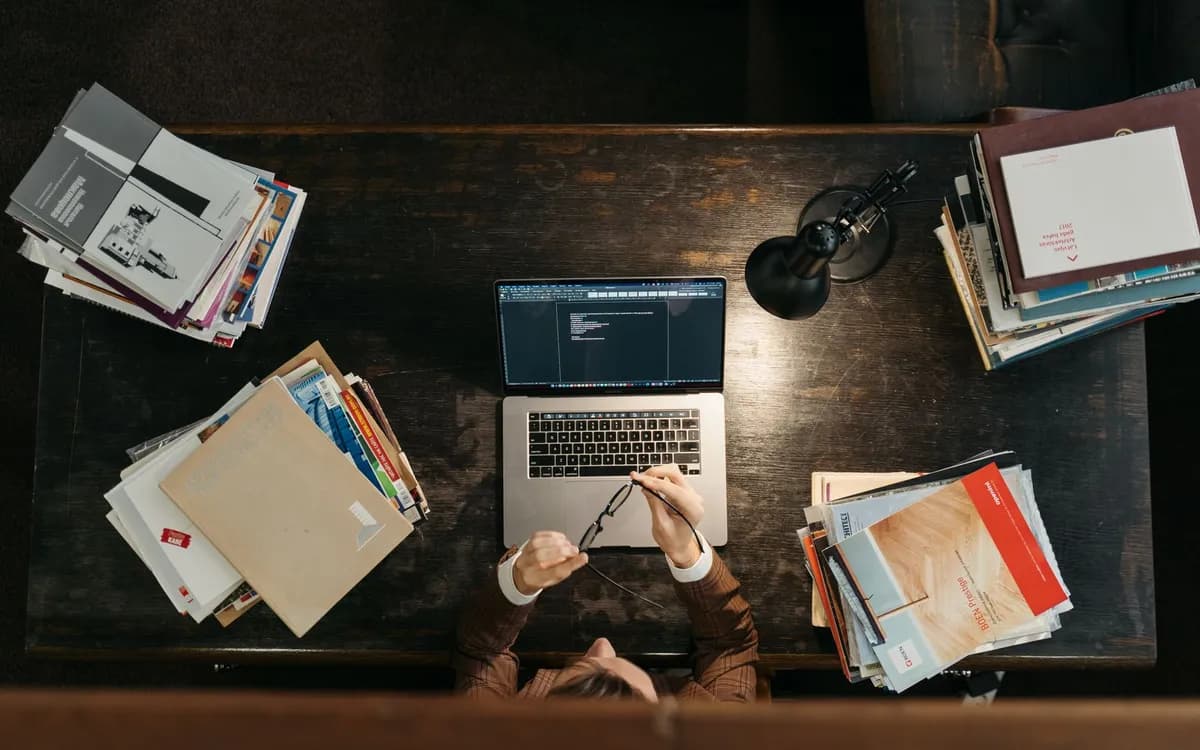 Visão de cima de uma mesa com notebook mostrando código