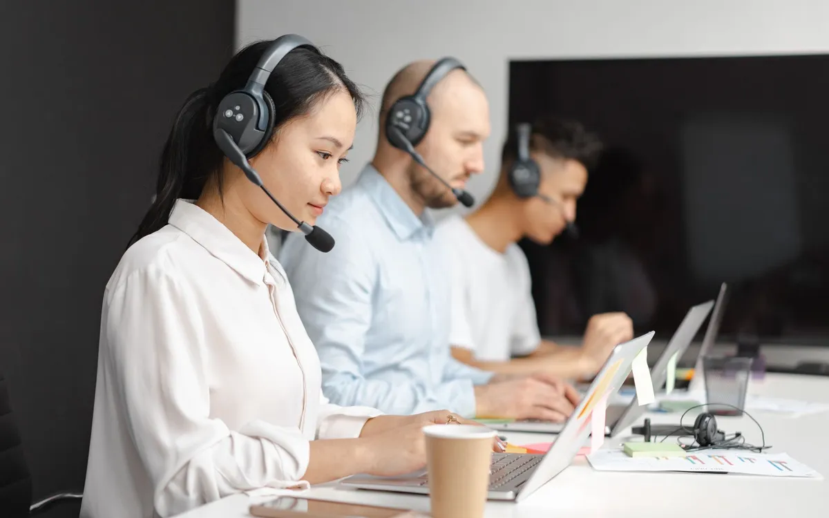 Equipe de suporte monitorando atendimentos com fones de ouvido